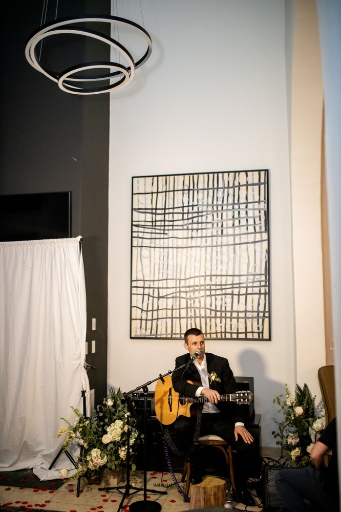 Coyah performing solo in a formal black suit at an upscale venue
